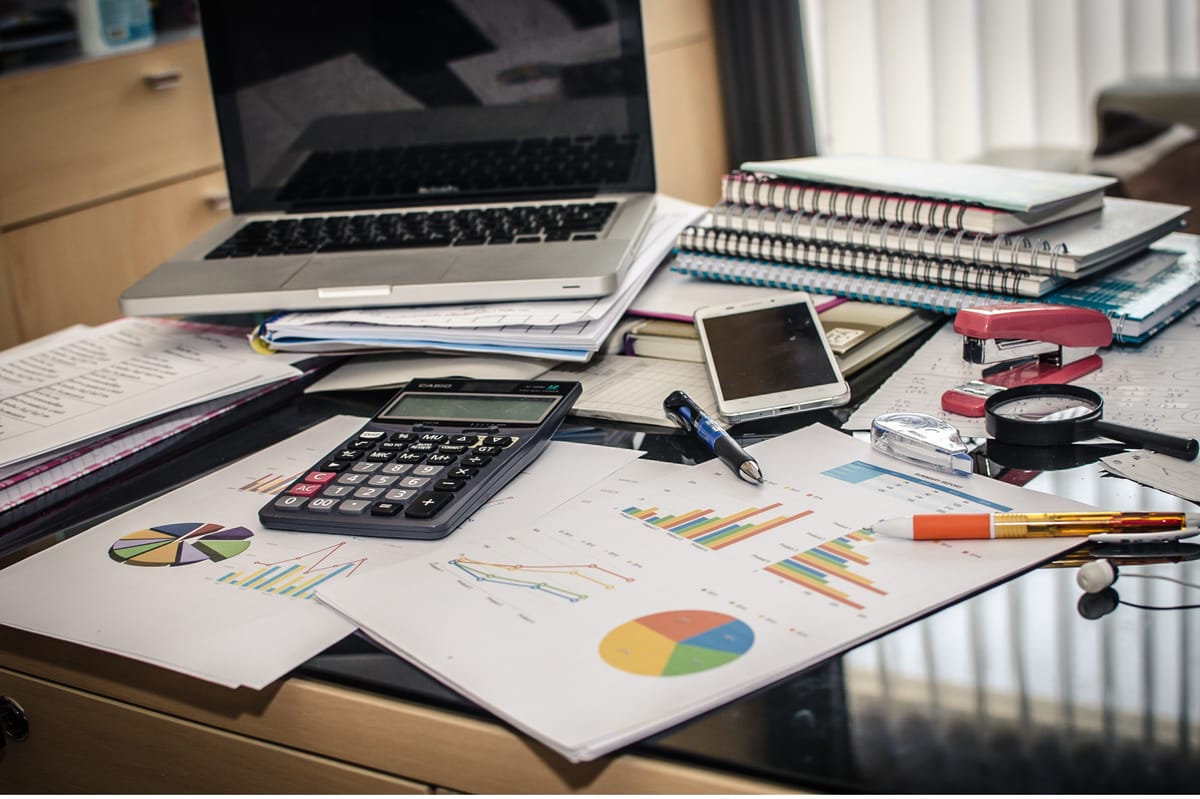 Finance desk with charts, calculator and reports, tracking SaaS renewals and subscription costs